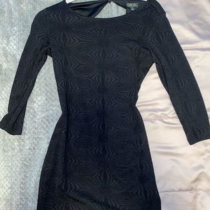 black tight fitting dress with open back.